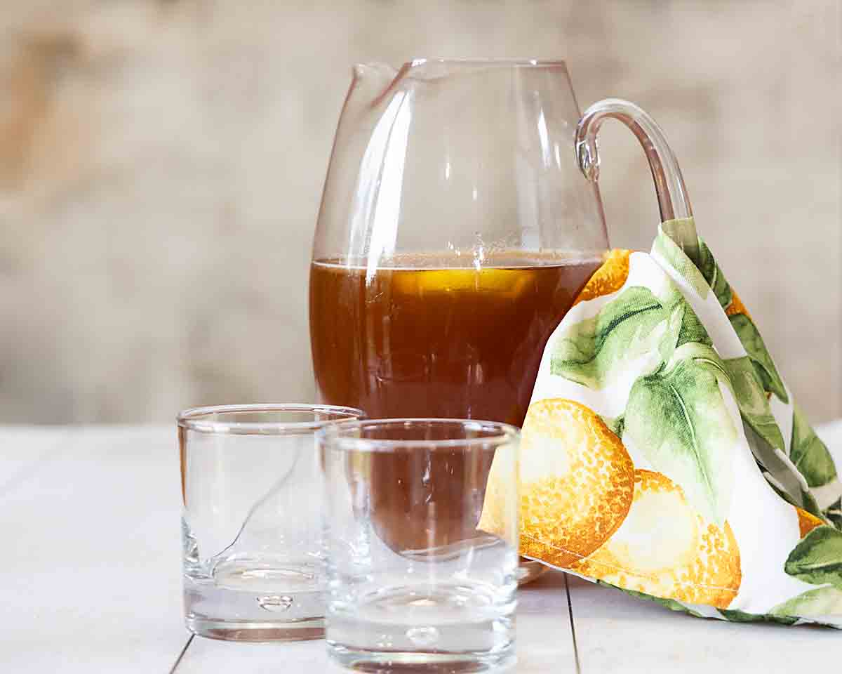 A pitcher of tea with two empty glasses