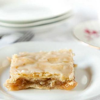 Glazed Apple Pie Bars are like a special slab pie--rich pie crust topped with apples, more crust, then glaze. Cut into bars, they are easy and delicious!