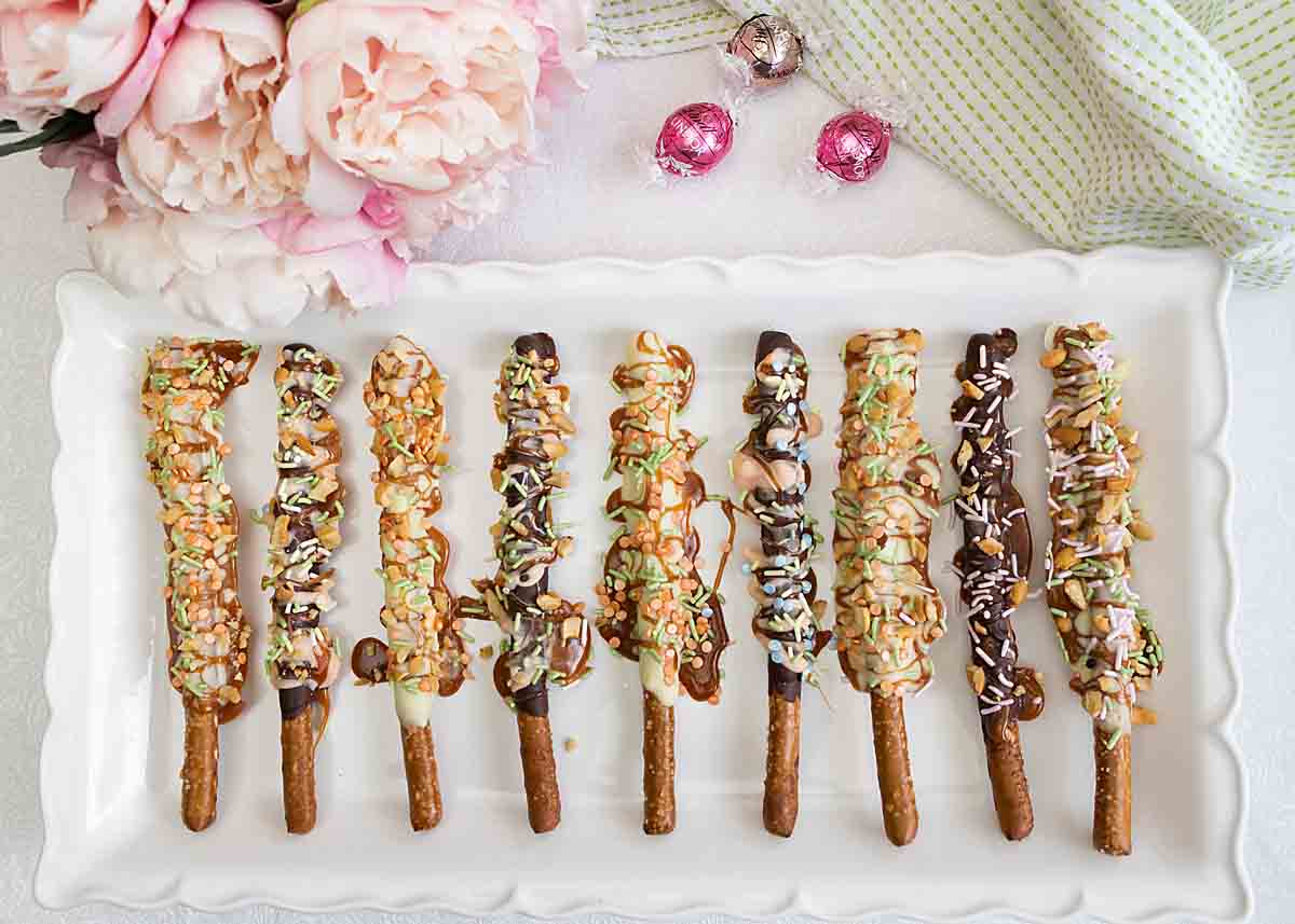 chocolate dipped pretzel rods in spring colors with sprinkles
