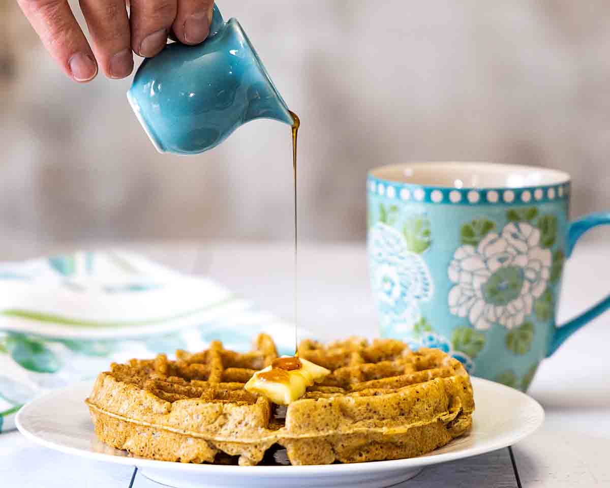 pouring syrup on a keto waffle