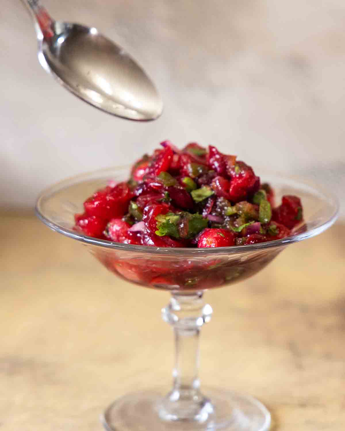 spooning out cranberry salsa