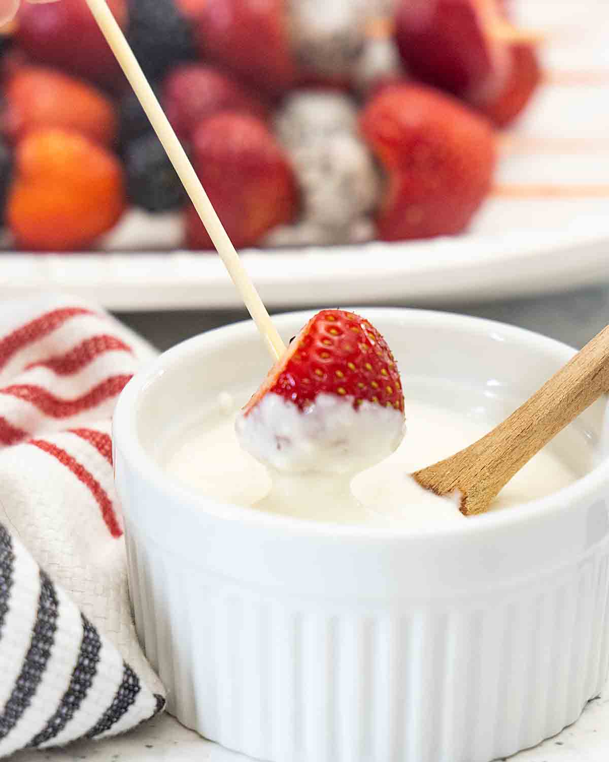 dipping strawberry into sauce