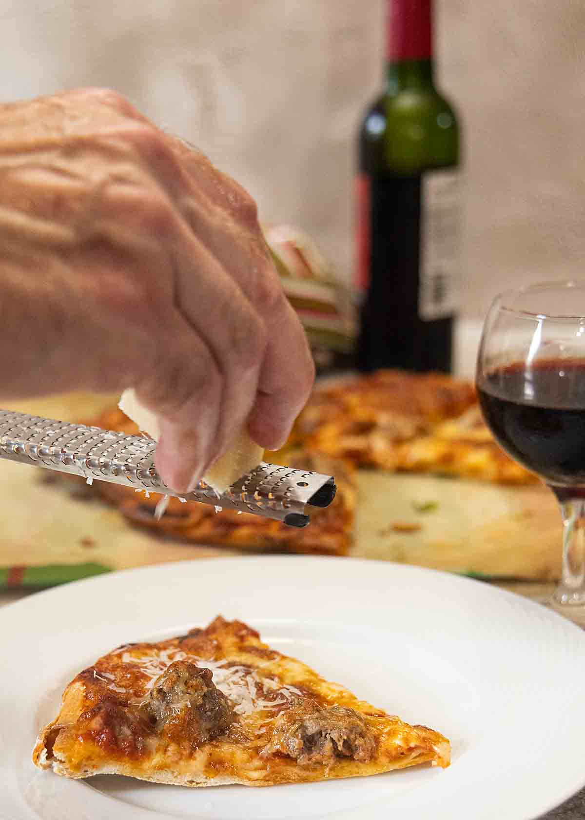 grating cheese over pizza